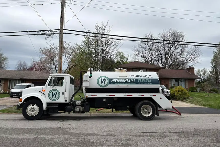 V1 Environmental company truck and septic pump pulled up in front of residential home - Southern Illinois