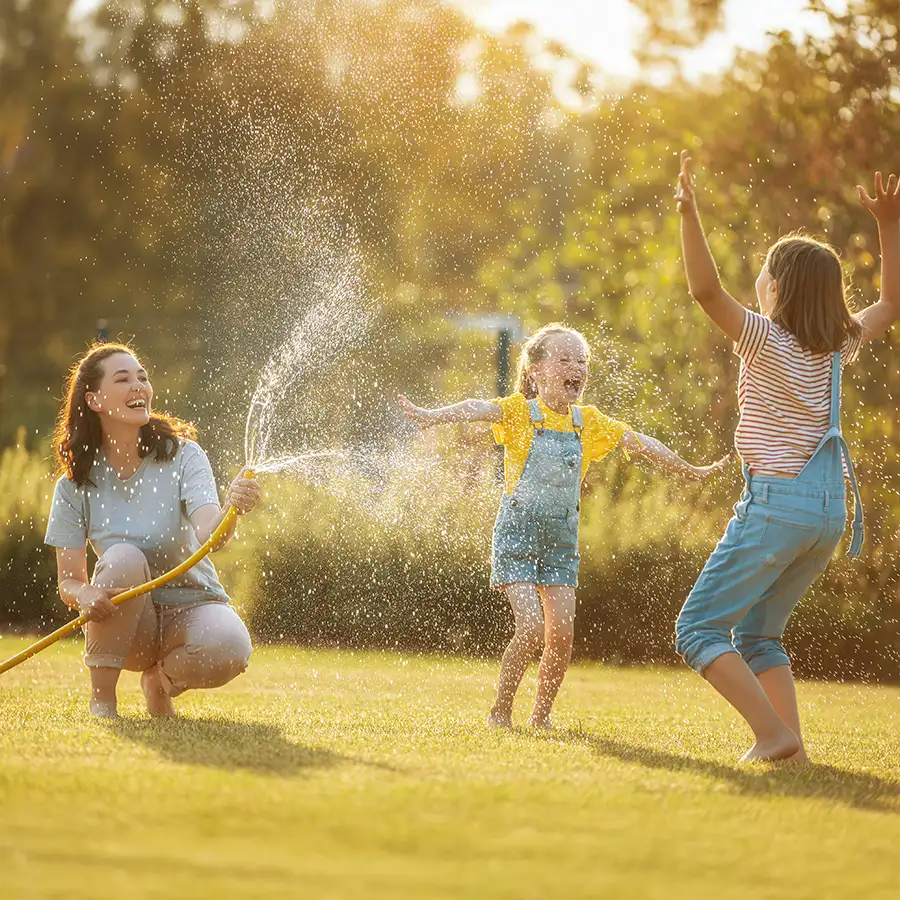 V1 Environmental - Benefits of Routine Septic Maintenance in St. Clair County, IL and Madison County IL, young family playing in the yard with garden hose